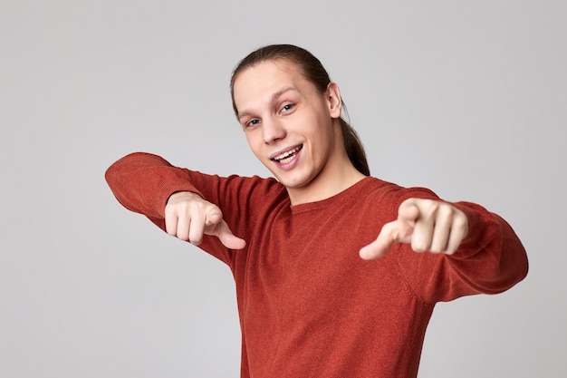 Retrato de um homem sorridente apontando para a câmera