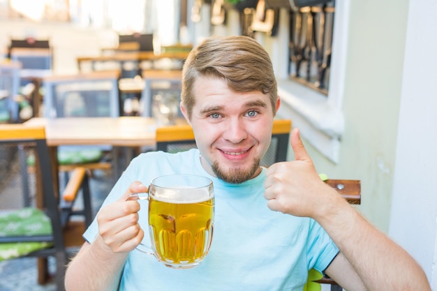 Retrato de um homem sorridente bebendo um copo