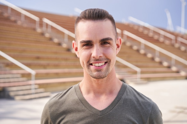 Retrato de um homem sorridente com o fundo do estádio