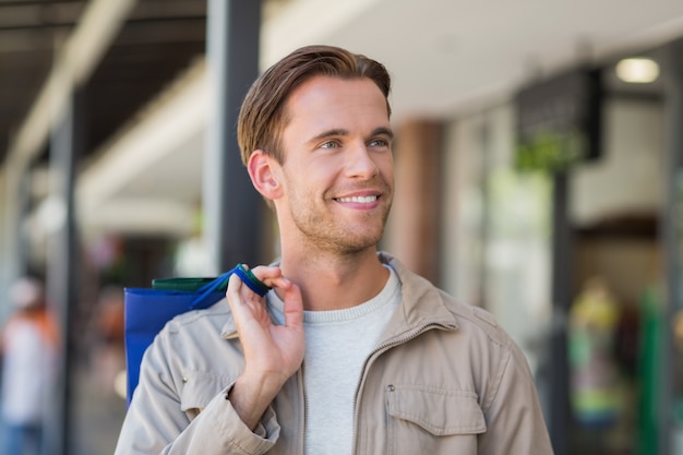 Retrato de um homem sorridente com sacolas de compras