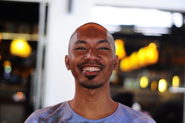 Retrato de um homem sorridente contra um equipamento de iluminação iluminado