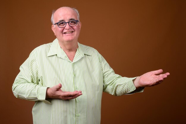 Foto retrato de um homem sorridente de pé contra um fundo cinzento