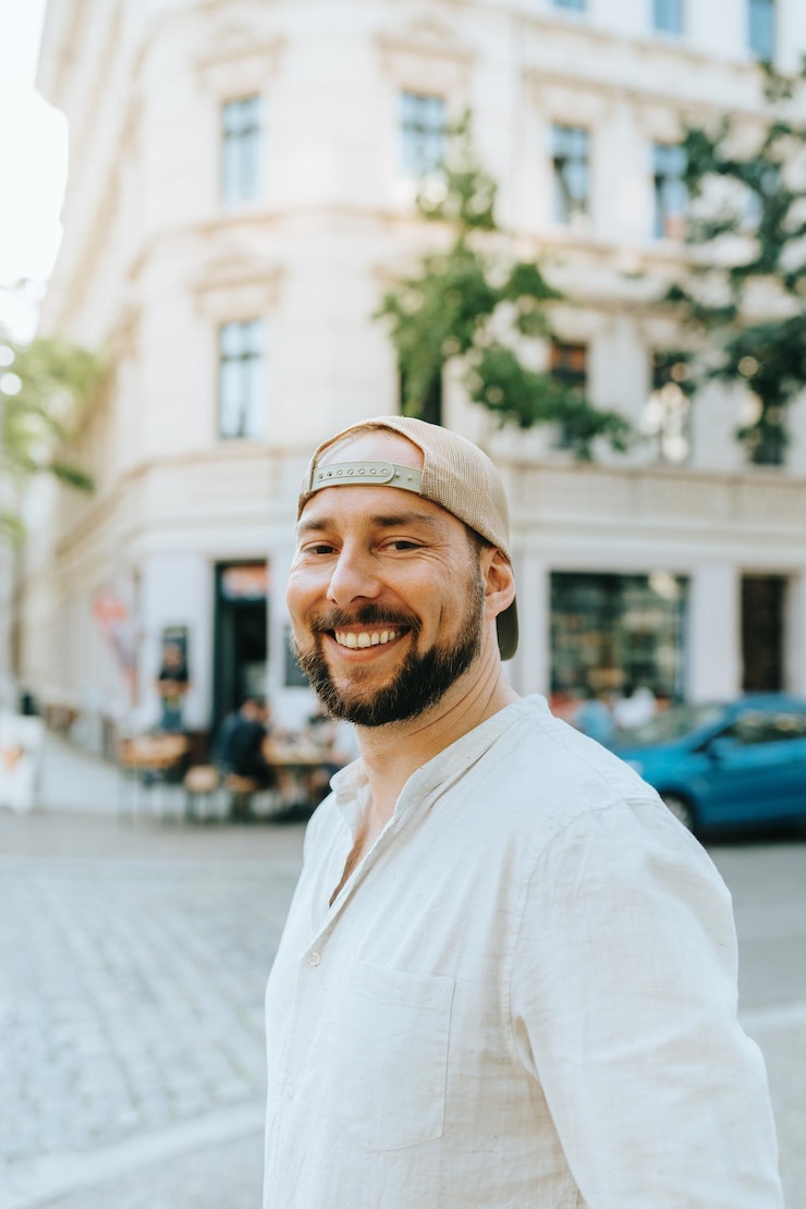 Foto retrato de um homem sorridente de pé na rua contra edifícios na cidade
