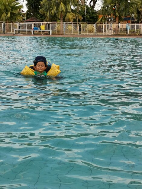 Foto retrato de um homem sorridente nadando na piscina