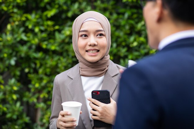 Retrato de um homem sorridente segurando café enquanto está de pé na câmera
