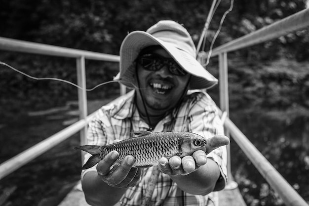 Foto retrato de um homem sorridente segurando um peixe