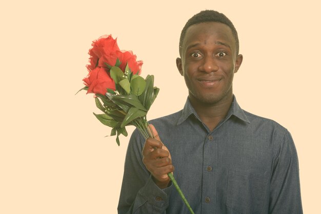 Foto retrato de um homem sorridente segurando uma flor contra um fundo branco