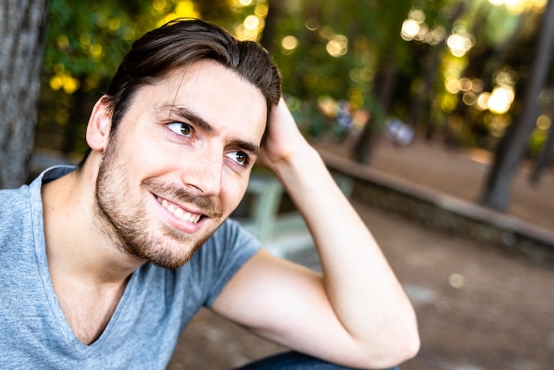 Retrato de um homem sorridente sentado ao ar livre