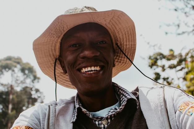 Foto retrato de um homem sorridente usando um chapéu ao ar livre