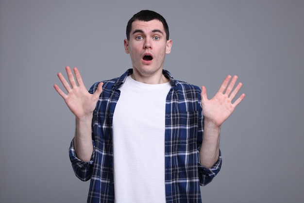 Retrato de um homem surpreso em fundo cinzento