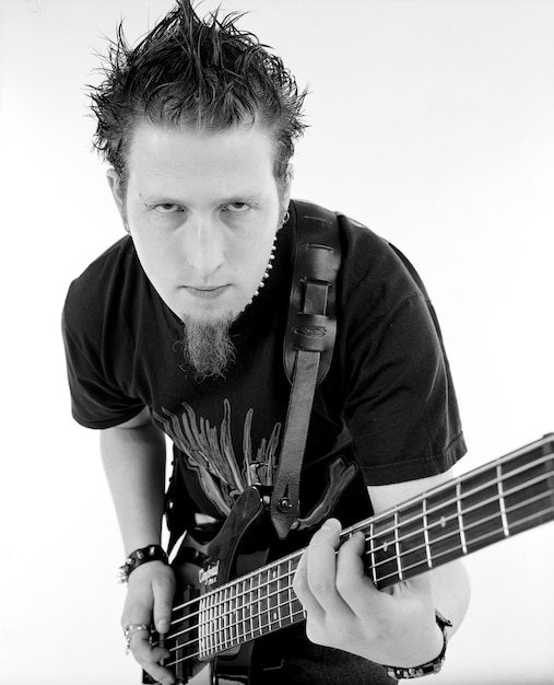 Retrato de um homem tocando guitarra contra um fundo branco