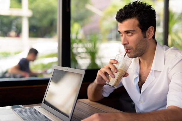 Retrato de um homem turco bonito relaxando em um café na cidade de Bangkok