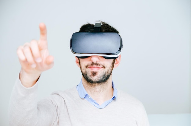 Retrato de um homem usando óculos de realidade virtual contra um fundo branco