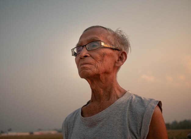 Foto retrato de um homem vestindo um chapéu contra o céu durante o pôr do sol