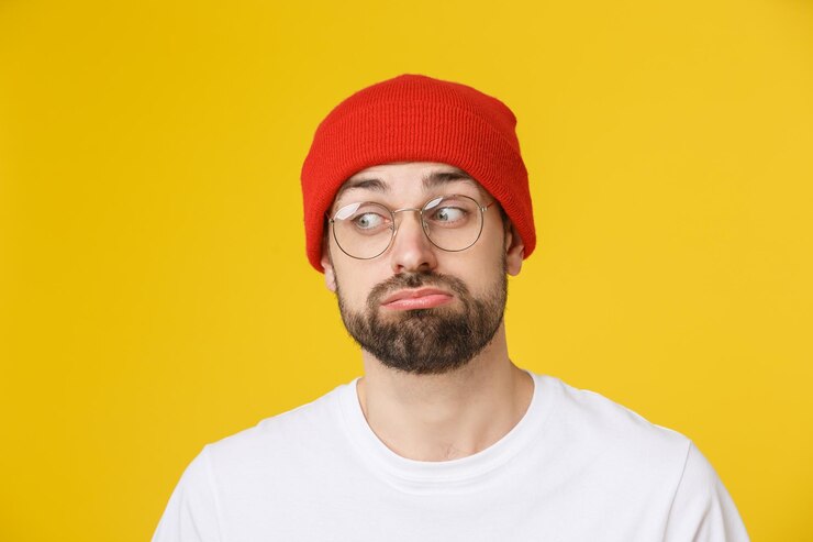 Foto retrato de um homem vestindo um chapéu contra um fundo amarelo