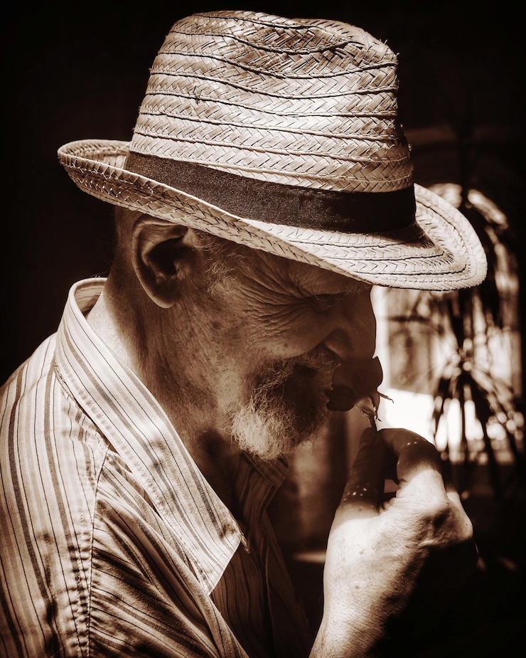Foto retrato de um homem vestindo um chapéu contra um fundo preto