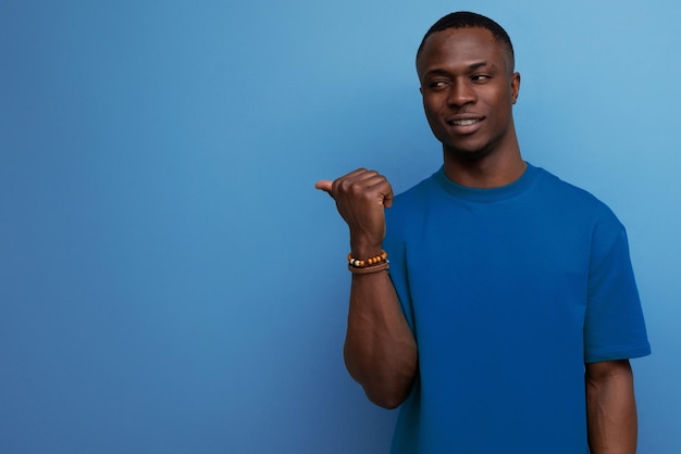 Foto retrato de um jovem africano atraente vestido com camiseta básica no fundo do estúdio com cópia