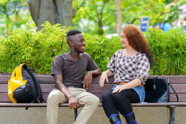 Foto retrato de um jovem africano e uma jovem ruiva juntos