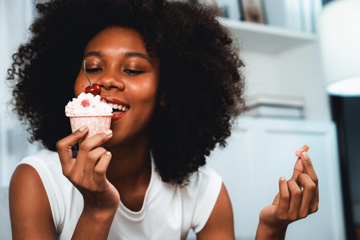 Foto retrato de um jovem africano provando bolo de cereja em conceito de prato especial.