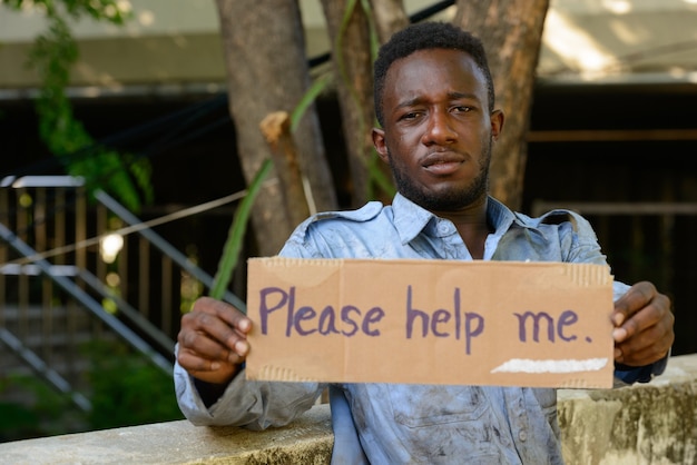 Retrato de um jovem africano sem-teto na ponte na rua ao ar livre