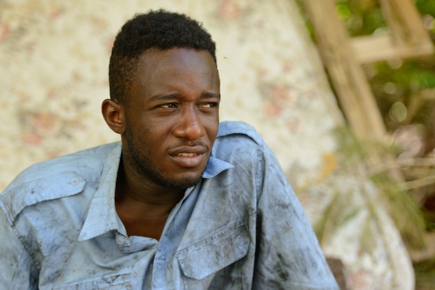 Foto retrato de um jovem africano sem-teto na rua ao ar livre
