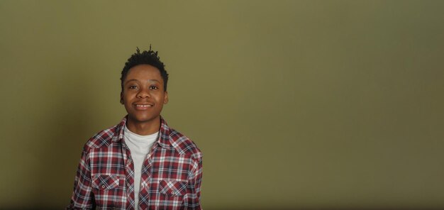 Foto retrato de um jovem afro-americano de camisa a quadros em fundo verde