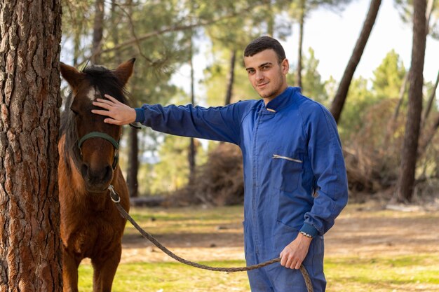 Retrato de um jovem agricultor acariciando seu cavalo