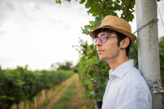 Retrato de um jovem agricultor em seu vinhedo, olhando para o futuro com confiança