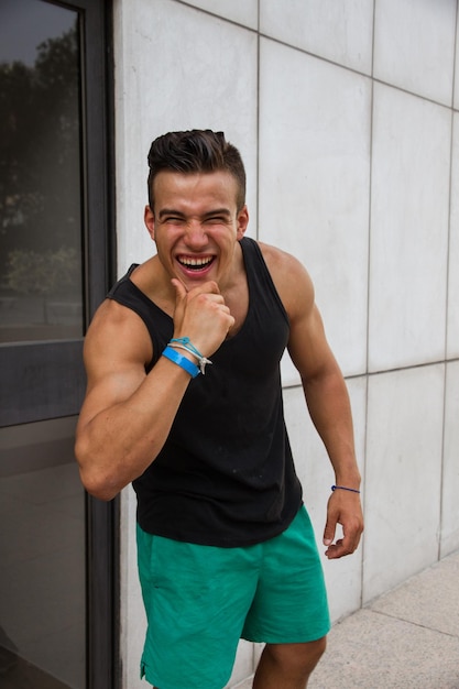 Retrato de um jovem alegre de pé contra a parede