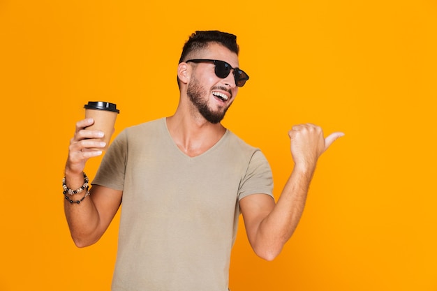 Foto retrato de um jovem alegre e casual em óculos de sol