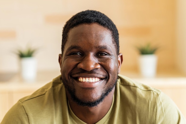 Retrato de um jovem alegre e feliz com camiseta branca casual em casa