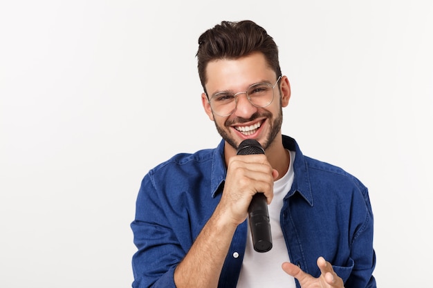 Retrato de um jovem animado em t-shirt isolado sobre fundo cinza, cantando.