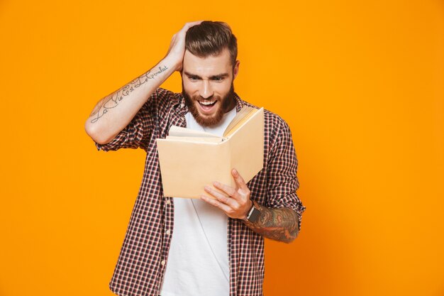 Retrato de um jovem animado, vestindo roupas casuais, segurando um livro de papel