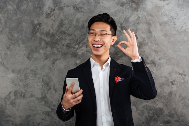 Retrato de um jovem asiático alegre vestido de terno