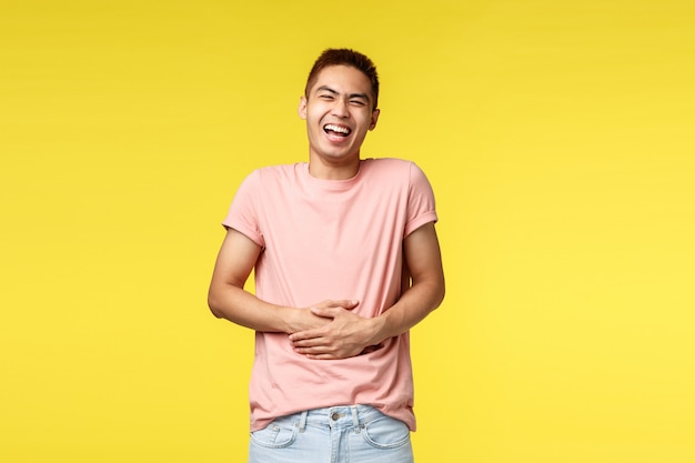 Retrato de um jovem asiático, mostrando o gesto sobre parede amarela