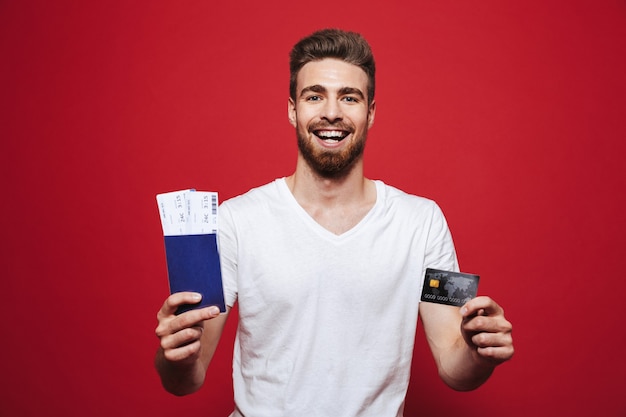 Retrato de um jovem barbudo alegre segurando um passaporte