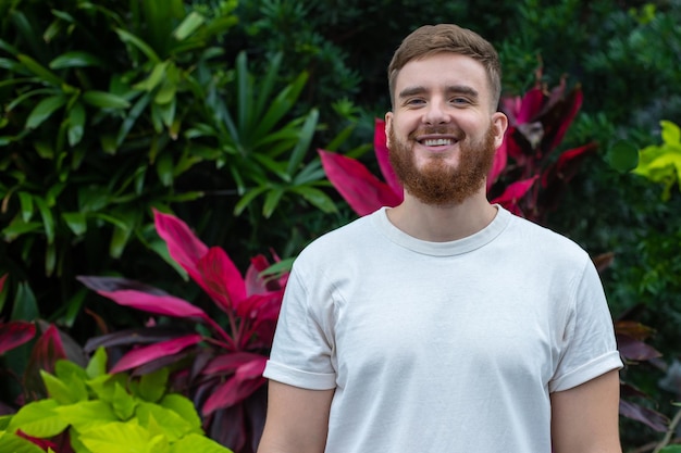 Retrato de um jovem barbudo feliz com barba respirando fundo inalando ar fresco em fundo natural