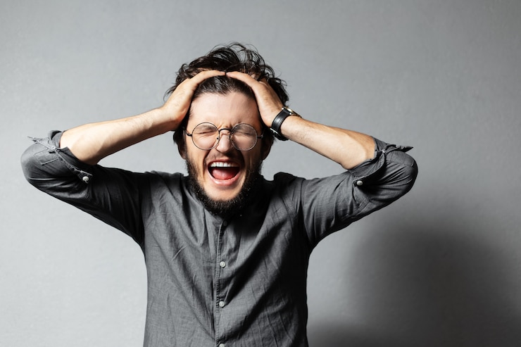 Foto retrato de um jovem barbudo gritando com cabelo despenteado e óculos