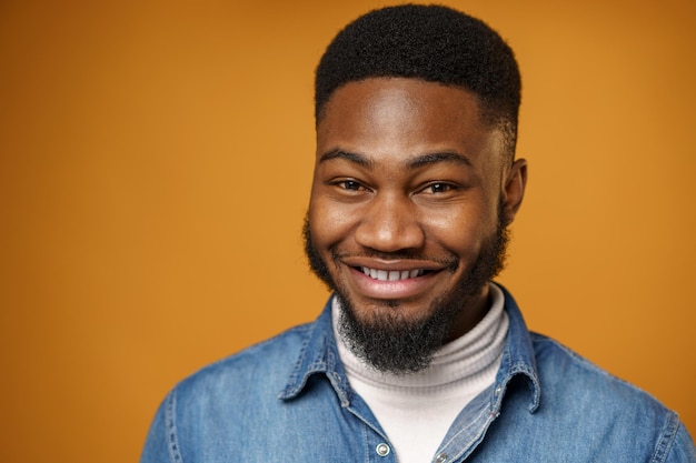 Retrato de um jovem bonito afro-americano contra um fundo amarelo