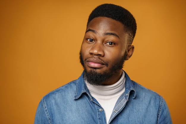 Retrato de um jovem bonito afro-americano contra um fundo amarelo