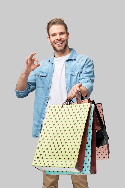 Retrato de um jovem bonito com sacolas de compras.