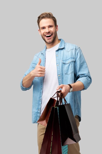 Retrato de um jovem bonito com sacolas de compras.