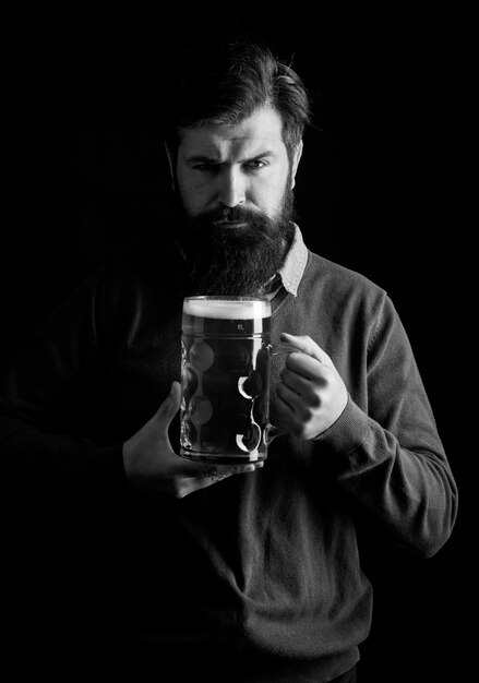 Retrato de um jovem bonito degustando uma cerveja de pressão elegante homem bonito de terno preto bebendo cerveja