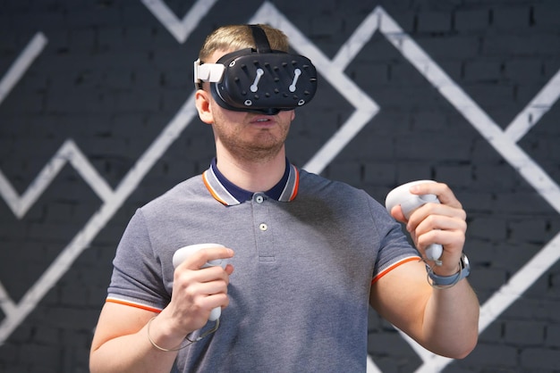 Retrato de um jovem bonito e feliz, sorridente, usando um dispositivo moderno virtual