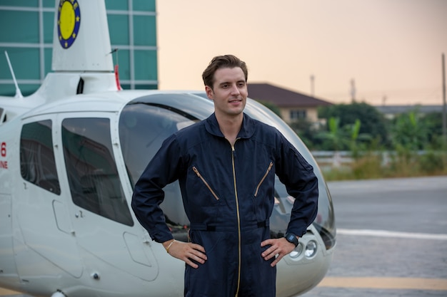 retrato de um jovem bonito em gesto uniforme de engenheiro técnico contra o aeroporto