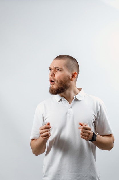 Retrato de um jovem bonito feliz parece longe com surpresa