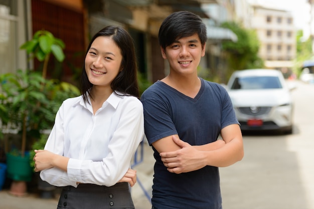Retrato de um jovem bonito filipino e uma jovem linda mulher asiática juntos nas ruas ao ar livre