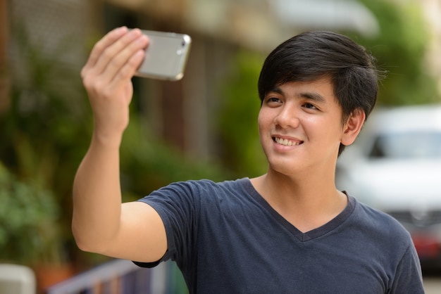 Retrato de um jovem bonito filipino na rua ao ar livre