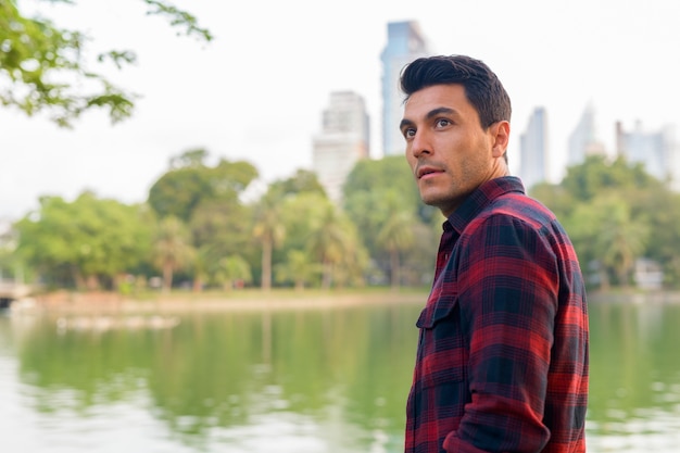 Retrato de um jovem bonito hispânico moderno no parque ao ar livre