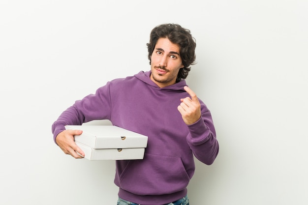 Retrato de um jovem bonito segurando pizza